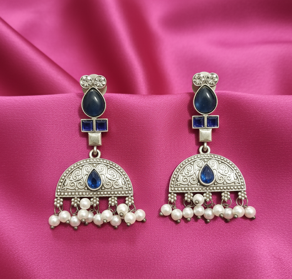Elegant Ornate silver earrings with blue stones and pearl-like beads .