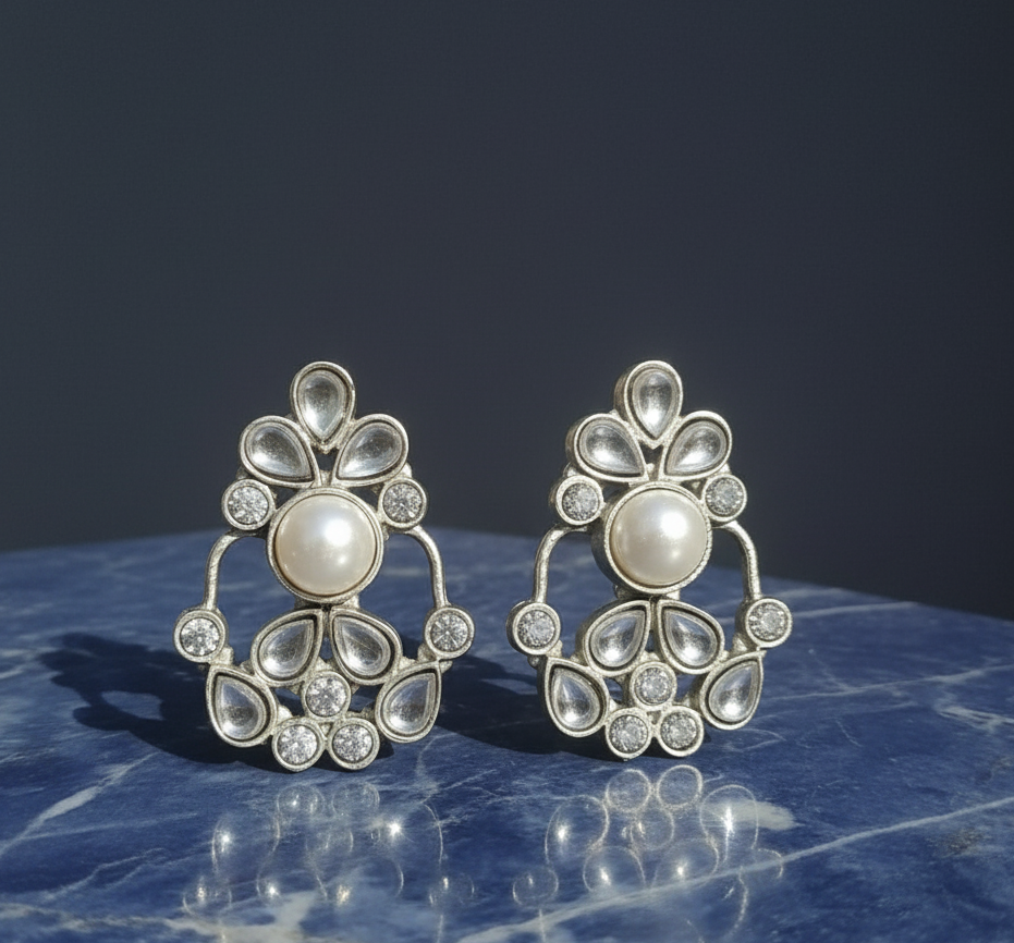 Pair of silver stud white kundan stone earrings .