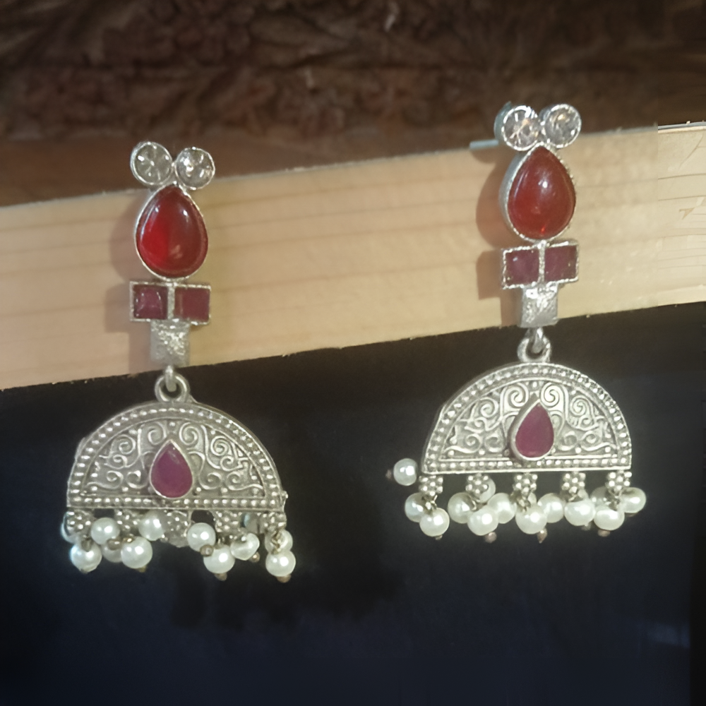 Elegant traditional earrings with red stones and pearl-like beads .