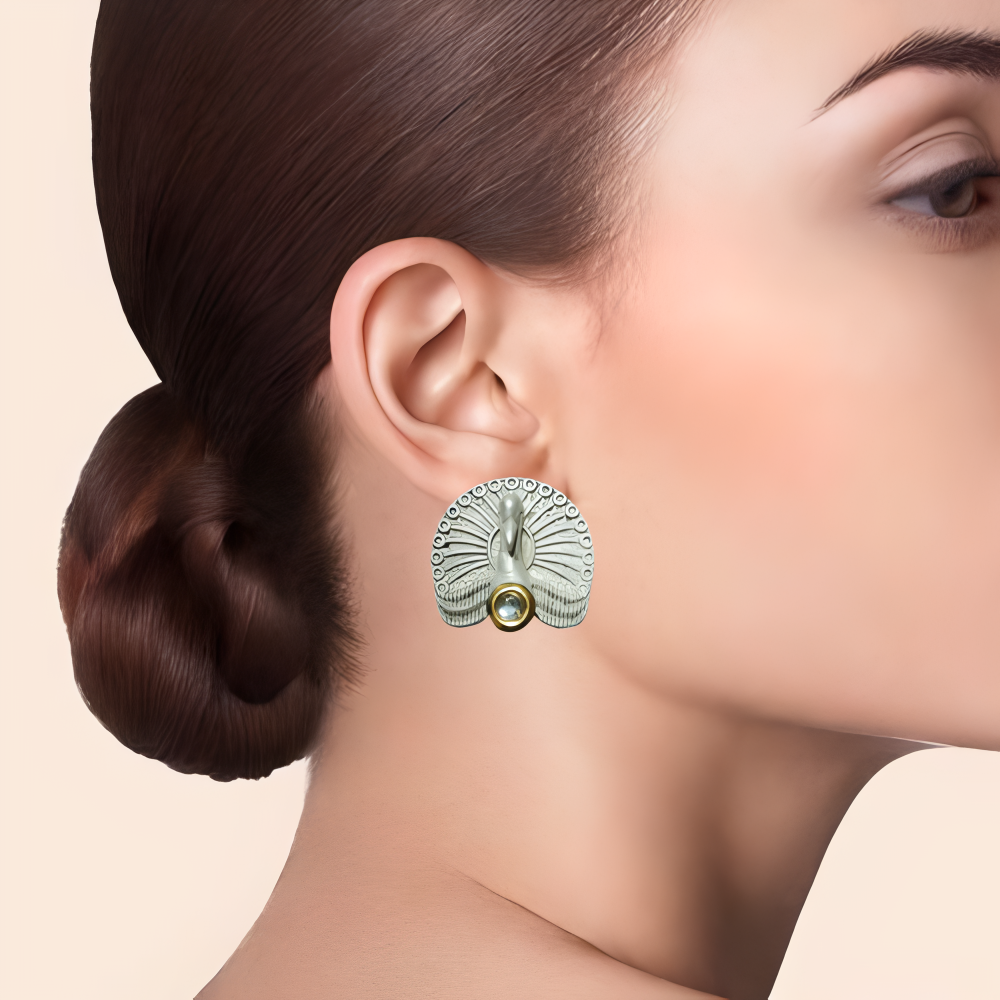peacock earrings being worn by a model .