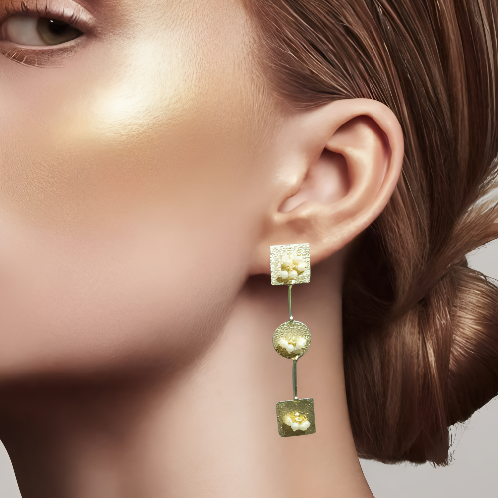 long golden earrings being worn by a model .