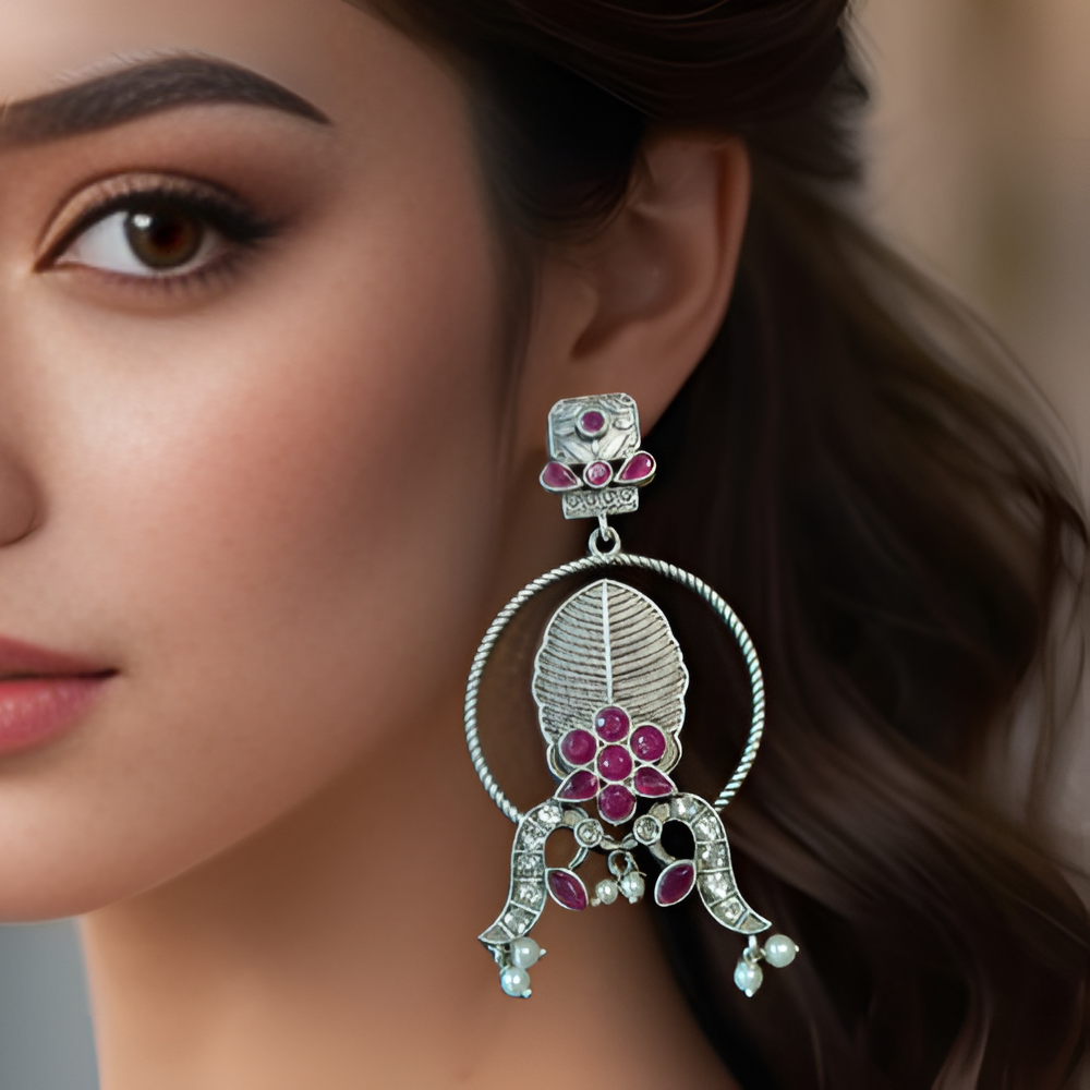 Close-up of a woman wearing a decorative earring with pink gemstones.