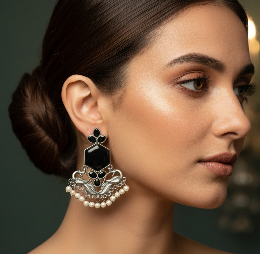 Profile close-up of a woman wearing Oxidised silver-tone ethnic earrings with detailed craftsmanship.
