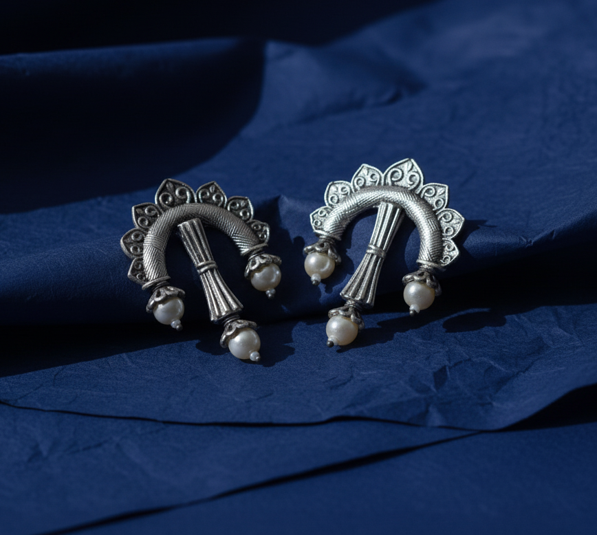Antique oxidised earrings in unconventional bow arrow shape .