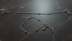Silver anklet with charms on a dark marble surface