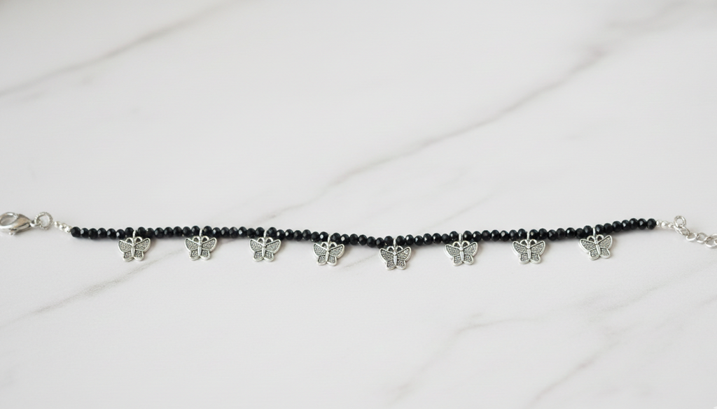 Elegant black bead ankle bracelet on a woman's ankle with a subtle western dress.