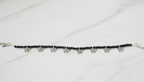 Elegant black bead ankle bracelet on a woman's ankle with a subtle western dress.