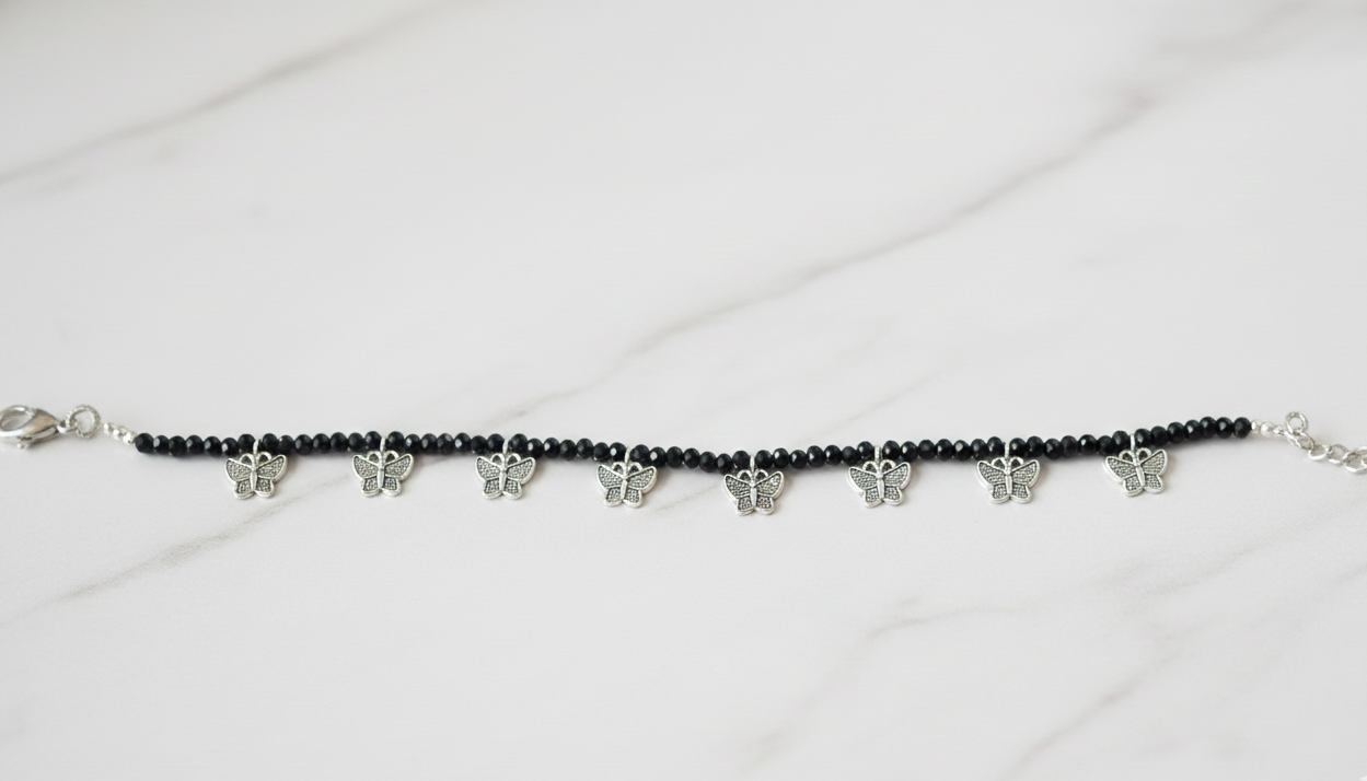 Elegant black bead ankle bracelet on a woman's ankle with a subtle western dress.