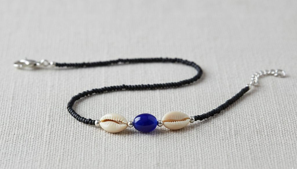 Ankle Bracelet with shell and blue bead on a light gray background