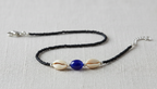 Ankle Bracelet with shell and blue bead on a light gray background