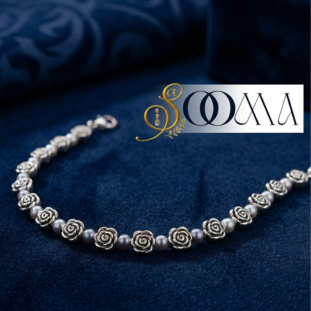 Silver ankle bracelet with rose-shaped charms on a blue fabric background, featuring the brand 'Sooma'.