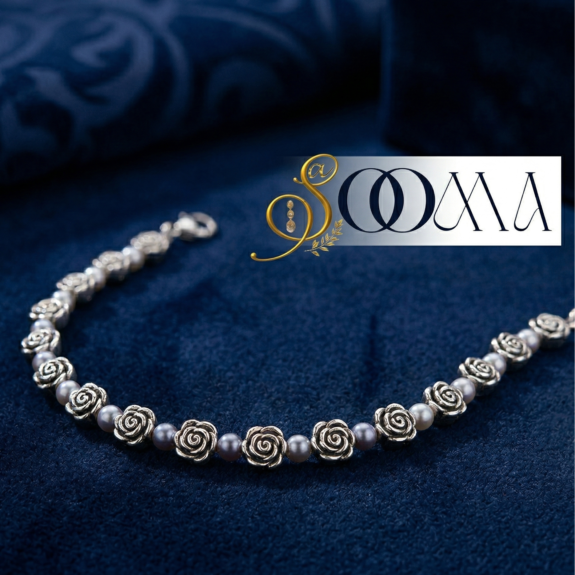 Silver ankle bracelet with rose-shaped charms on a blue fabric background, featuring the brand 'Sooma'.