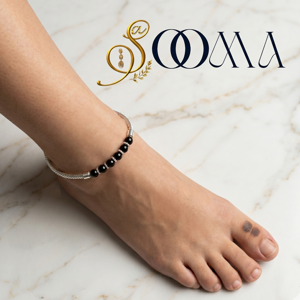 Person wearing a black beaded anklet on a marble surface with 'Sooma' branding.