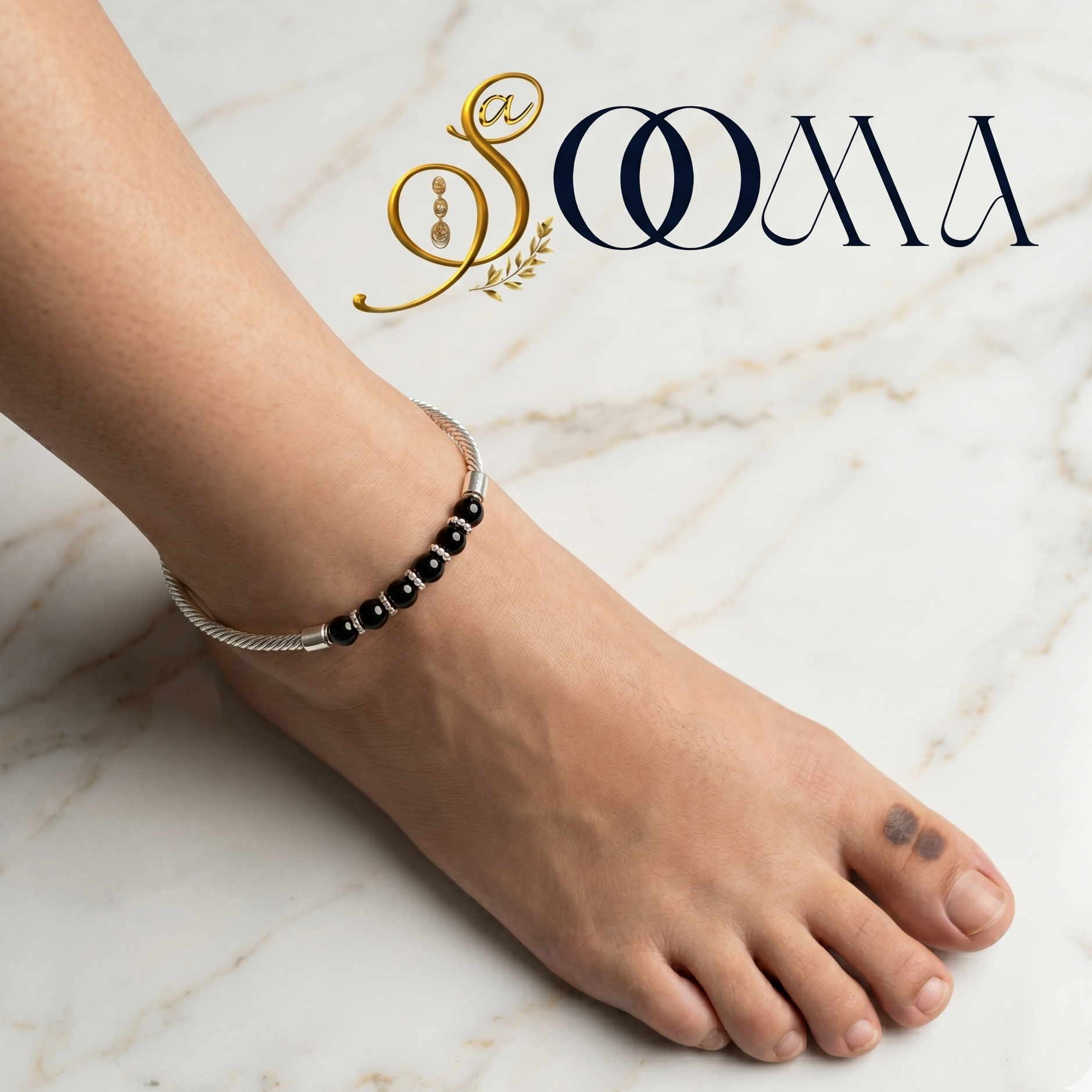 Person wearing a black beaded anklet on a marble surface with 'Sooma' branding.
