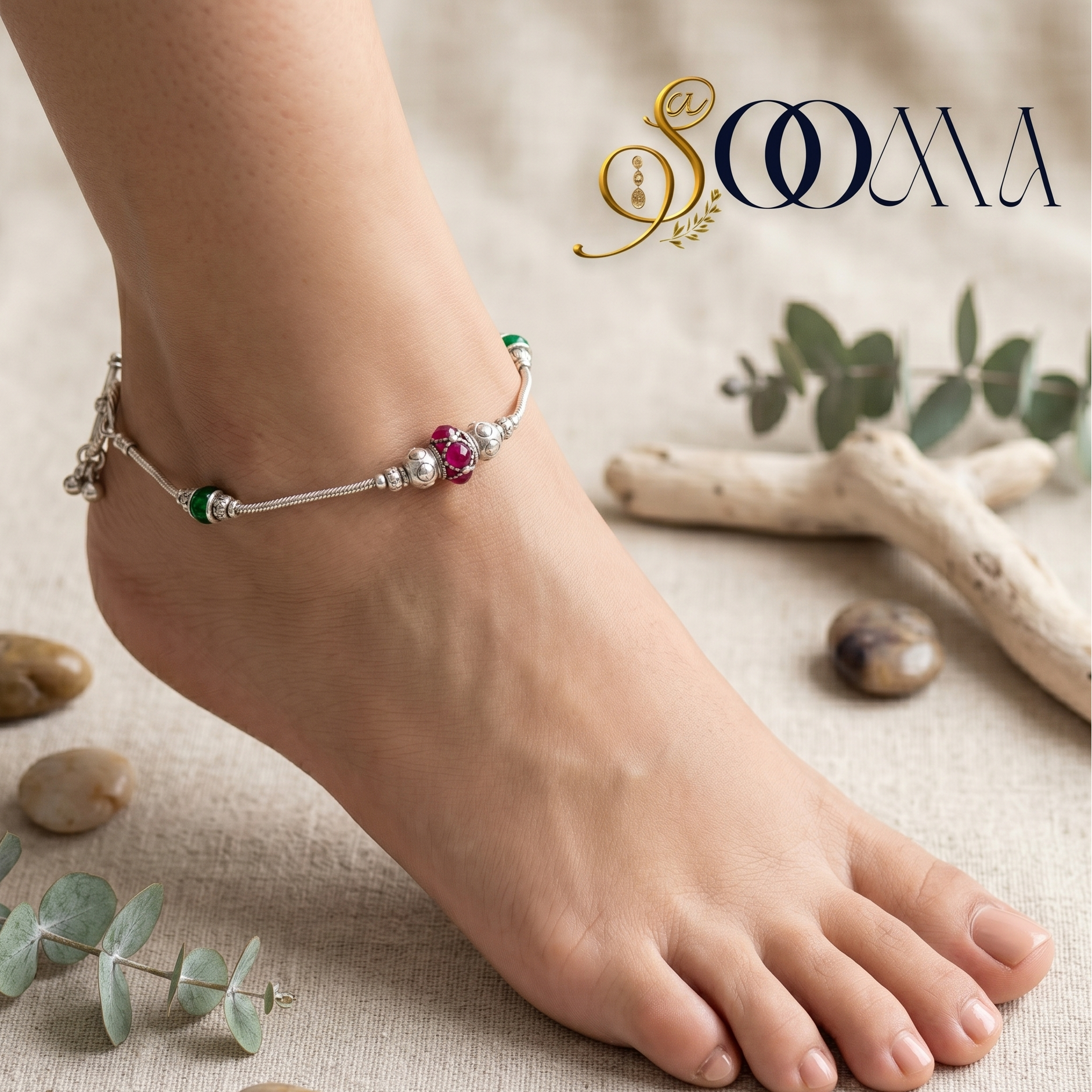 Anchored anklet on a foot with a natural background featuring stones and eucalyptus leaves, branded 'Sooma'.