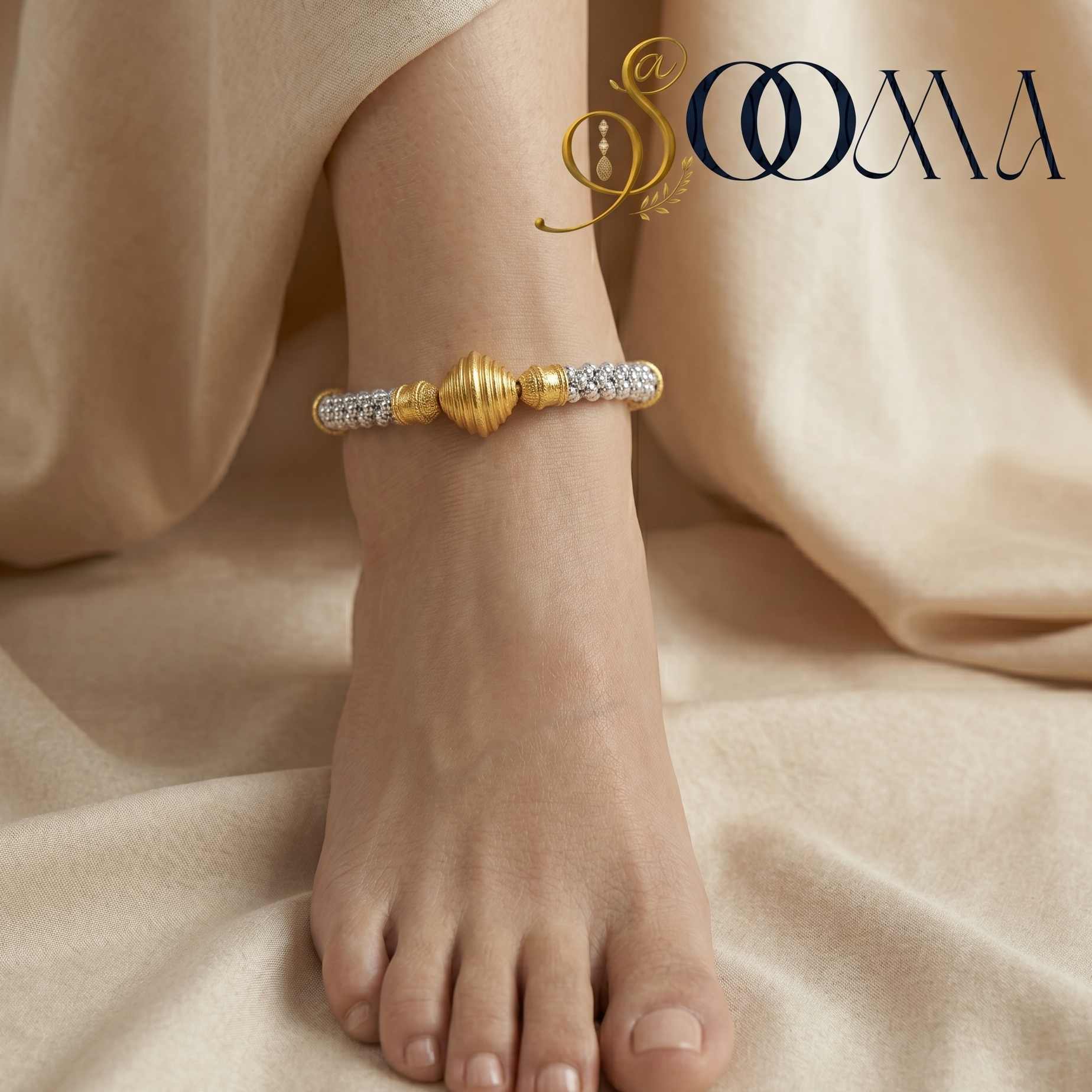 Gold anklet on a foot with 'Sooma' branding against a beige fabric background