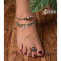 A Woman Wearing Boho Anklet Stack with Toe Ring featuring multi-colored beads and delicate charms.