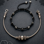 Elegant anklet stack featuring layered designs and a polished finish, perfect for office wear on a dark surface.