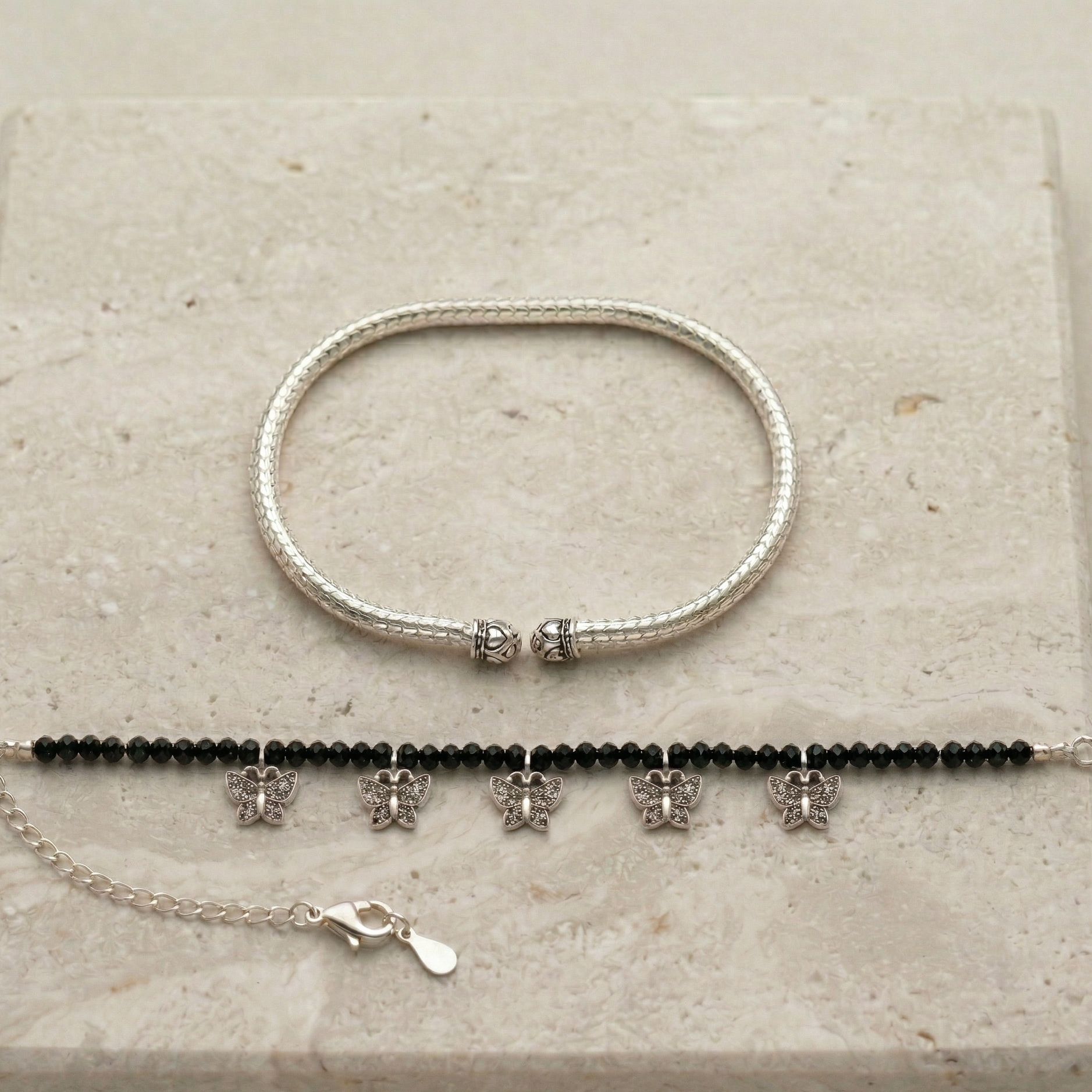 Elegant ankle bracelet with boho chic design on a stone background.
