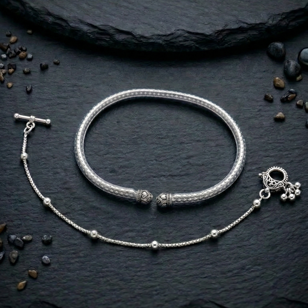Oxidized silver payal anklet & kada with intricate design on a earthy surface