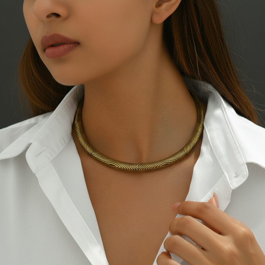 Woman wearing a gold hasli necklace with a plain white collared shirt