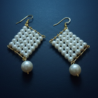 Pair of pearl earrings on a dark blue background