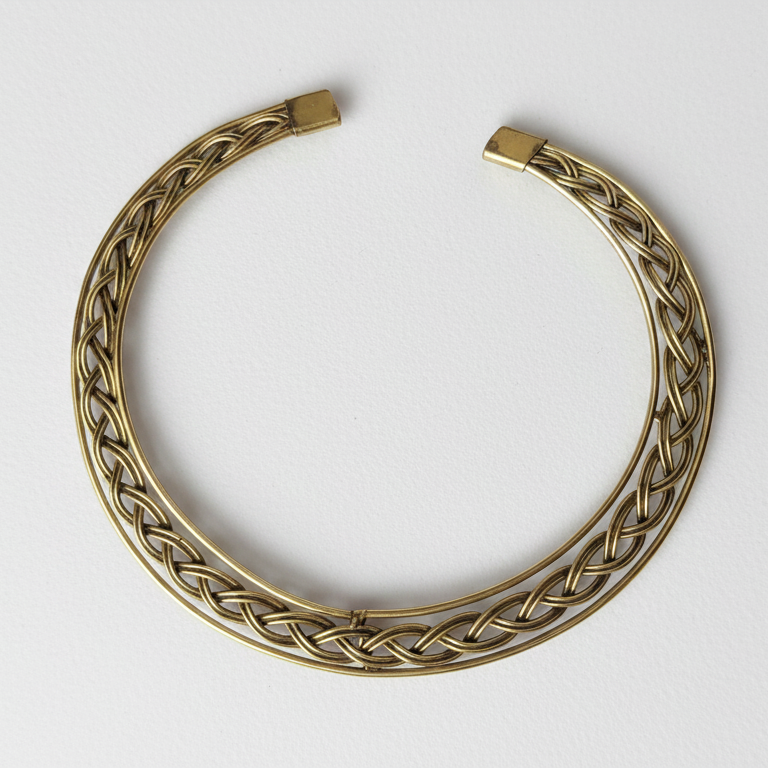 Elegant braided brass hasli necklace, perfect statement officewear for modern Indian woman, on a white background.