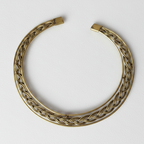 Elegant braided brass hasli necklace, perfect statement officewear for modern Indian woman, on a white background.