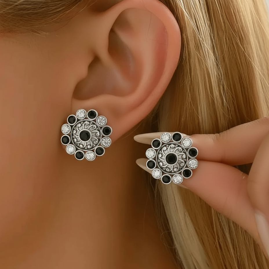 Close-up of a woman wearing Black & White oxidized silver Kundan stud earrings .
