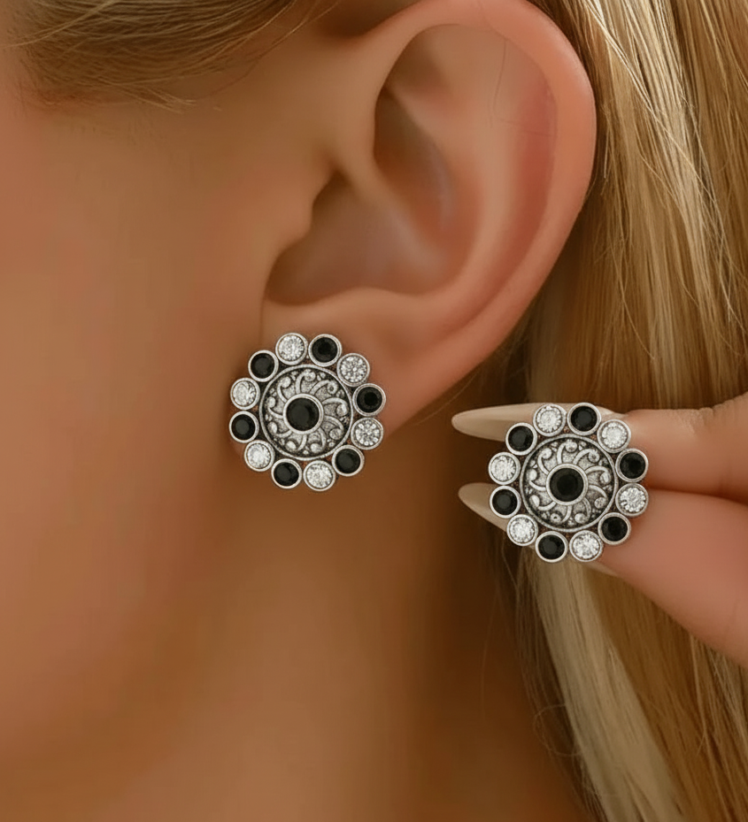 Close-up of a person wearing decorative earrings with a blurred background