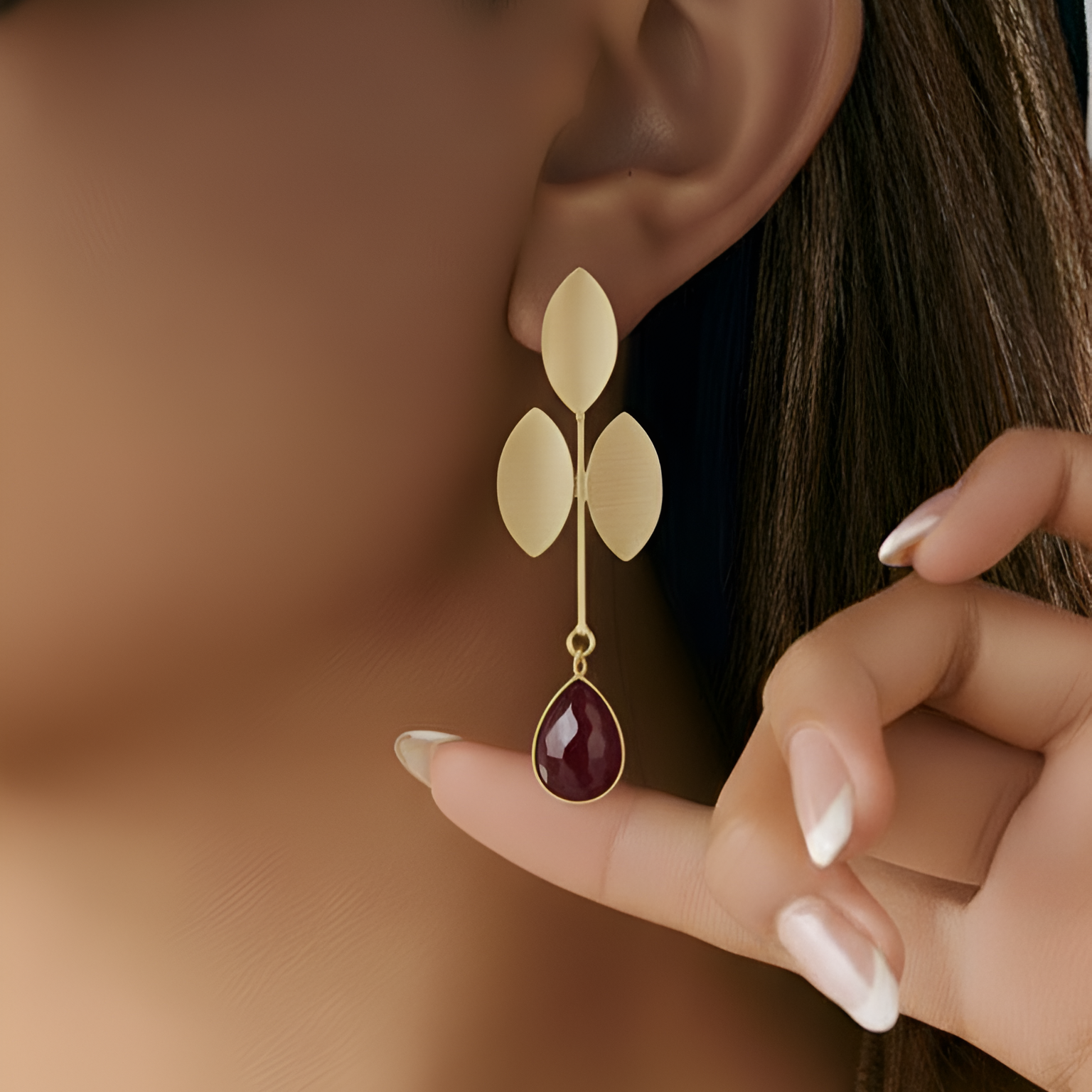 Close-up of a person wearing exquisite floral gold pearl earrings .