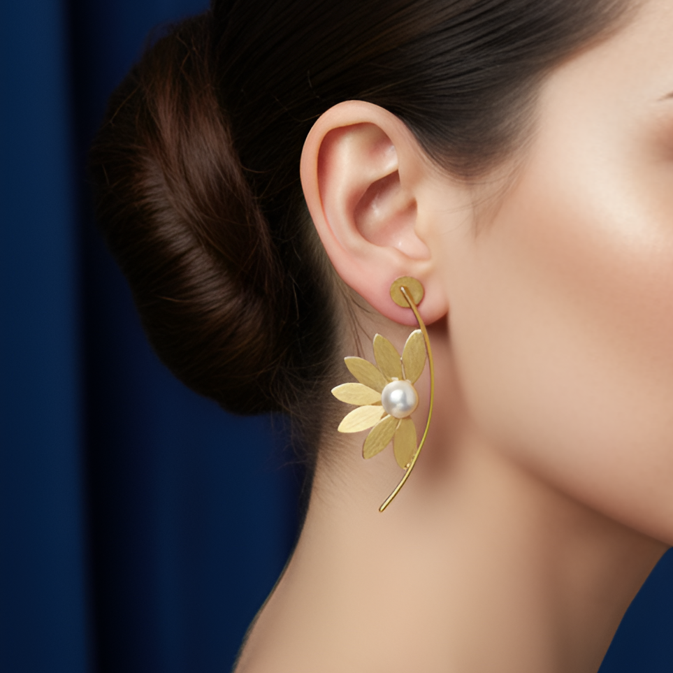 Close-up of a woman wearing a beautiful gold floral statement earrings.
