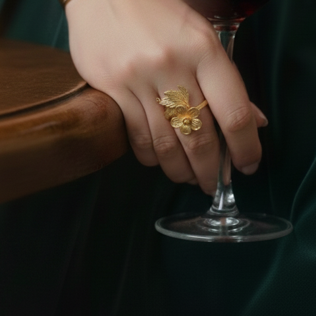 Hand holding a glass of red wine with Elegant Pretty Rose Ring.