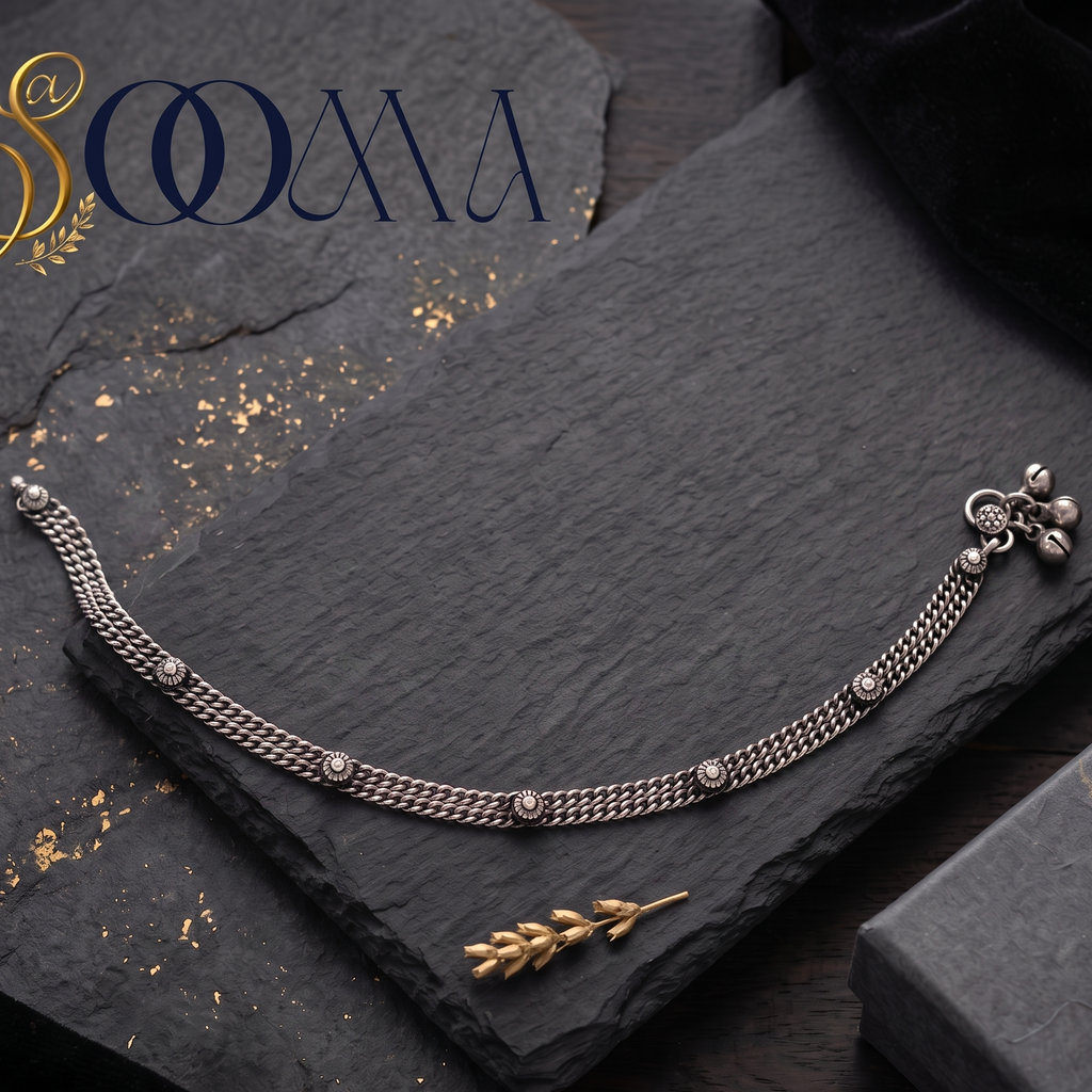 Sooma brand handcrafted oxidized silver double curb link anklet with rosette motifs displayed flat on a dark slate slate board with a black gift box