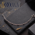 Sooma brand handcrafted oxidized silver double curb link anklet with rosette motifs displayed flat on a dark slate slate board with a black gift box