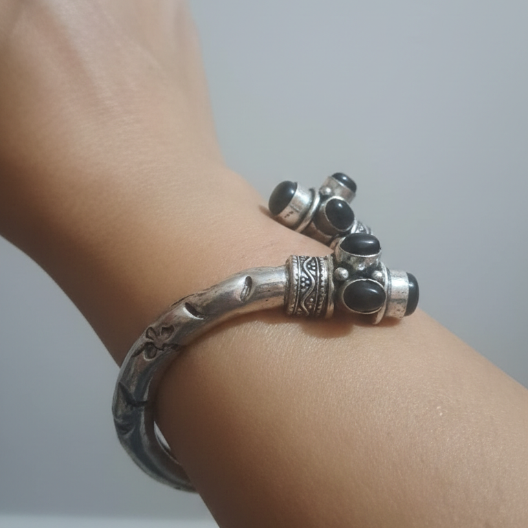 Close-up of a wrist wearing stylish oxidised kada showcasing its intricate detailing and vintage finish.