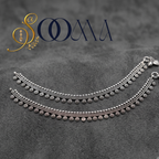 Sooma brand pair of oxidized silver floral drop payal anklets displayed flat on a textured grey surface