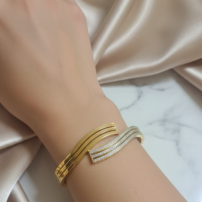 Close-up of a gold-plated bracelet with a secure clasp on a wrist, showcasing its radiant finish and sleek design.