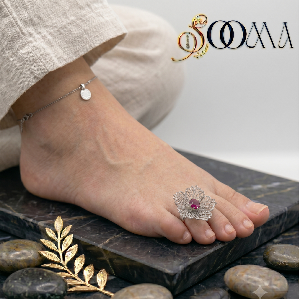 Front view of an adjustable handcrafted silver mesh flower statement toe ring with a ruby red center stone on a foot