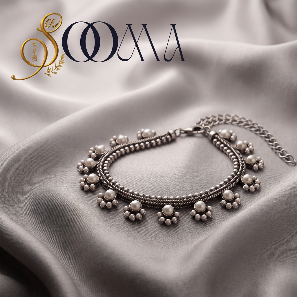 Handcrafted oxidized silver armlet bajuband with white pearl clusters displayed flat on a wrinkled grey satin fabric