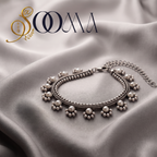 Handcrafted oxidized silver armlet bajuband with white pearl clusters displayed flat on a wrinkled grey satin fabric