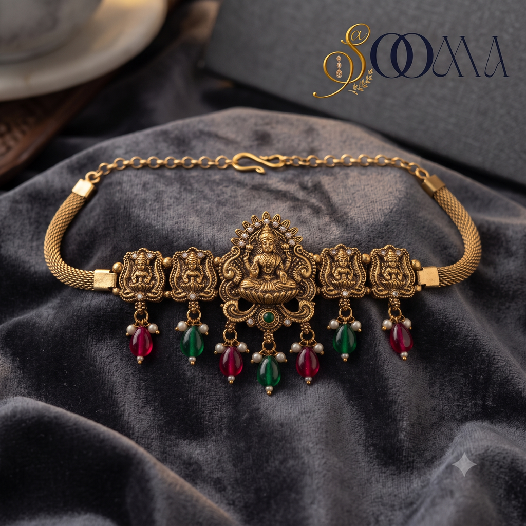Sooma brand antique gold temple jewelry armlet featuring an engraved Goddess Lakshmi centerpiece flat lay on grey velvet fabric