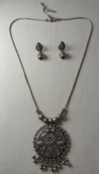 Handmade silver pendant for daily wear on grey background .