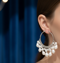 A model wearing silver hoop earring with pearl-like beads 