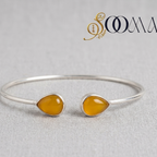 Sooma brand open cuff silver ankle kada with twin amber yellow teardrop cabochons displayed flat