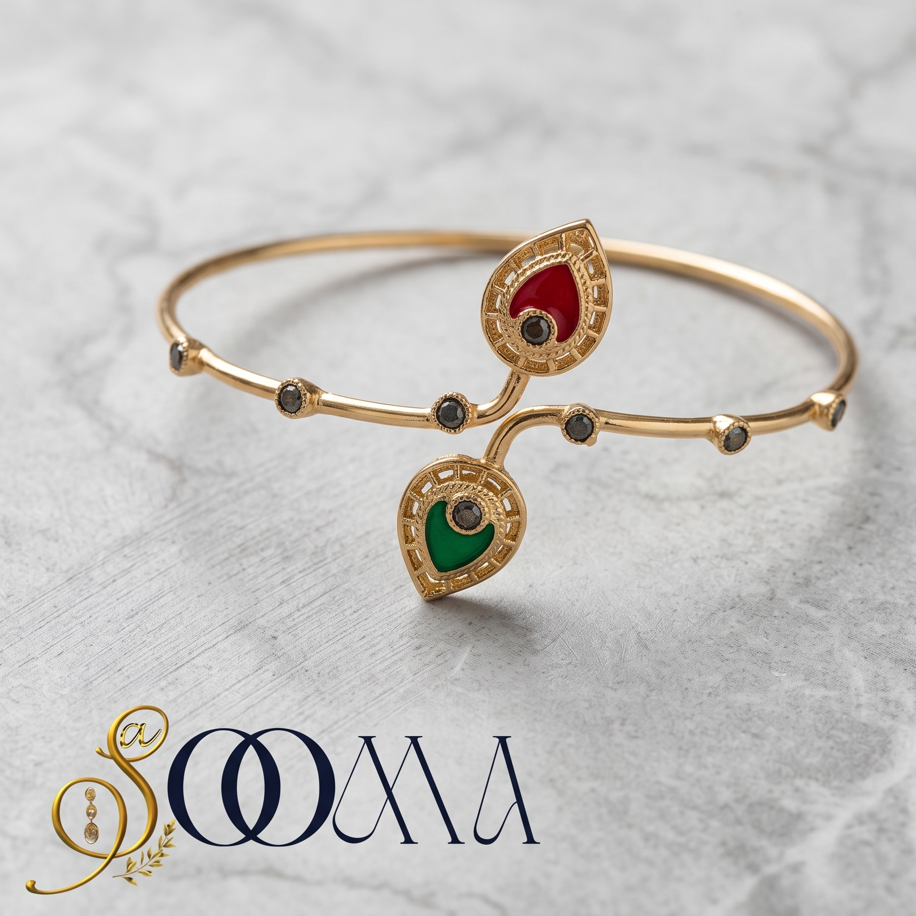 A gold-plated bangle bracelet with two teardrop-shaped enamel inlays, one red and one green, accented with small black stones, displayed on a light gray marble background with the brand name 'SOOMA' at the bottom.