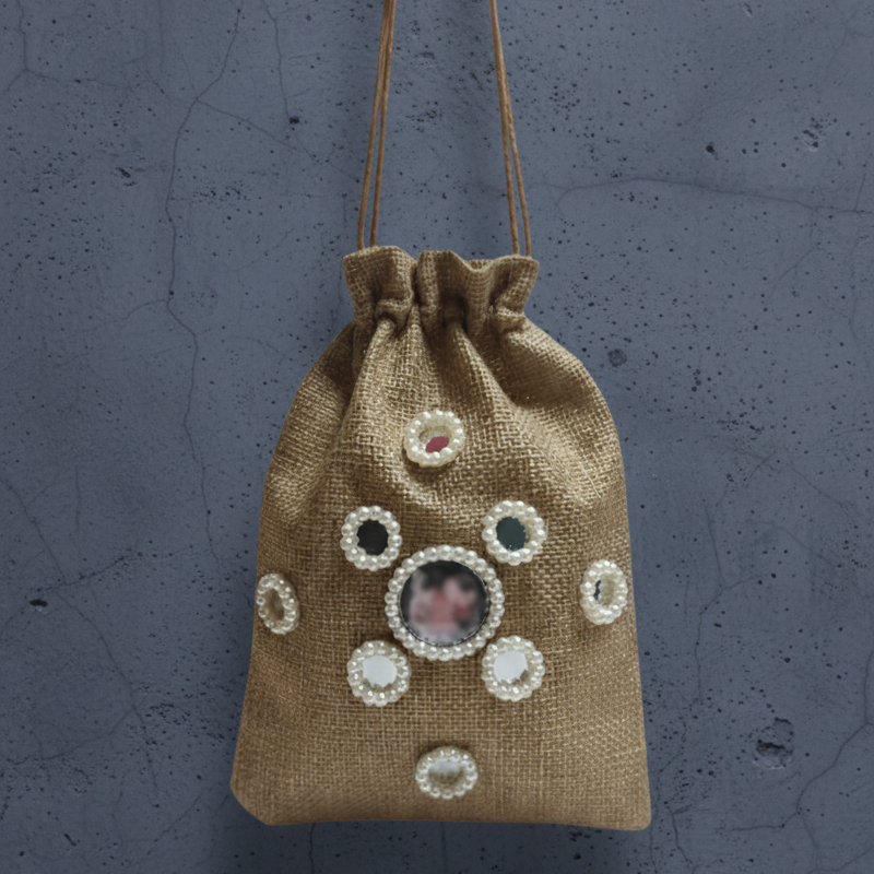 Jute drawstring bag with decorative elements on a gray background