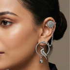 Woman wearing elegant earcuff chain earrings against a neutral background