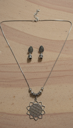 Geometric Pendant Set, minimalist design, high-polish finish, office-appropriate jewelry on a wooden background.