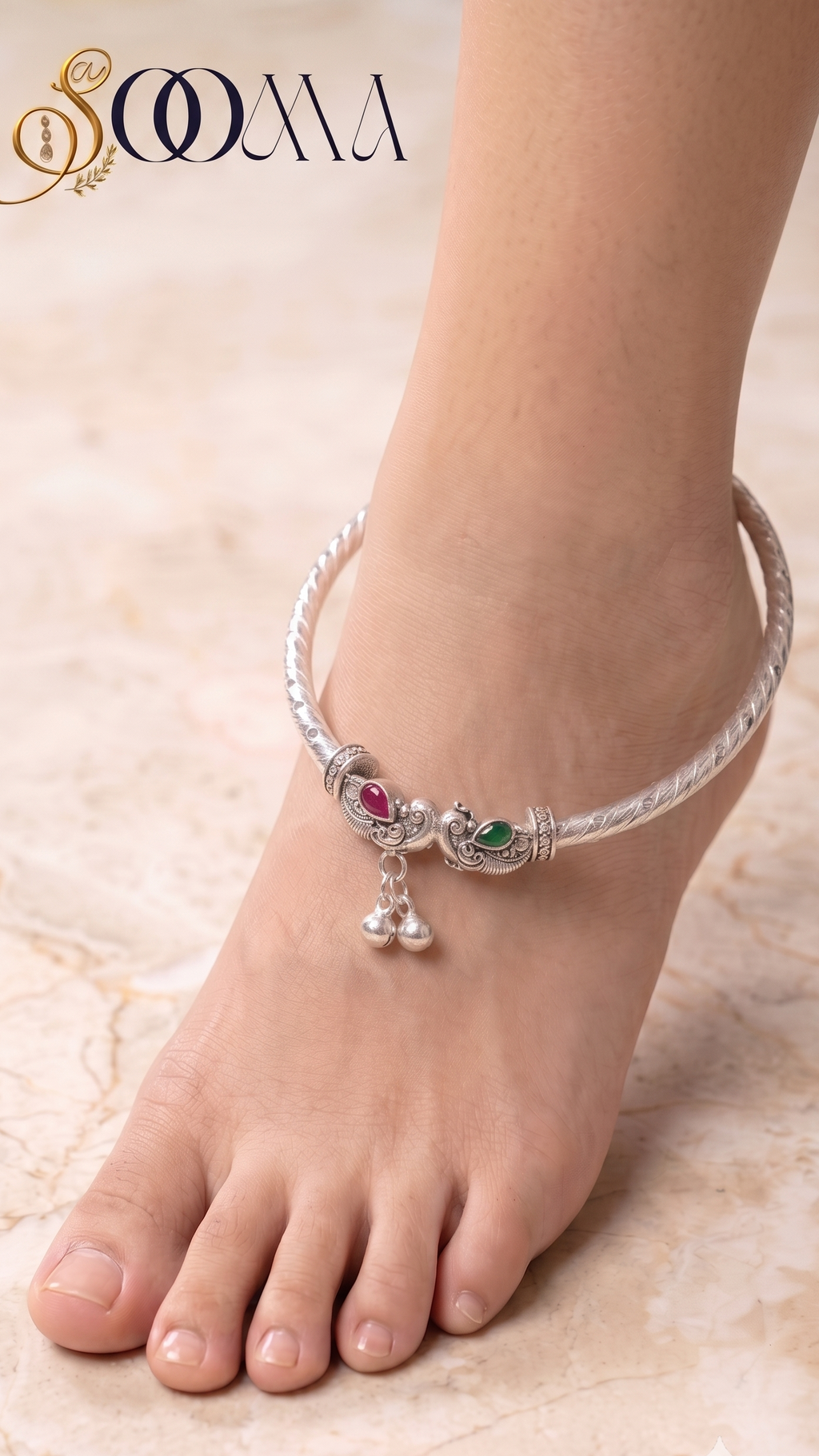 Top-down perspective of woman's foot wearing rigid silver elephant payal with green and ruby stones